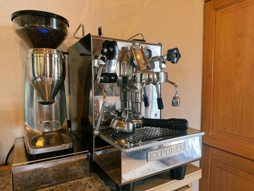 eine Kaffeemaschine auf einer Theke neben einem Mixer in der Unterkunft Romantisches Wellness Chalet im steirischen Ursprung 