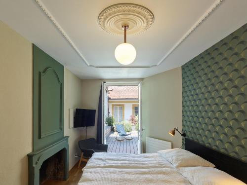 ein Schlafzimmer mit einem Bett und einer grünen Wand in der Unterkunft ADLER Boutique Hotel in Murten