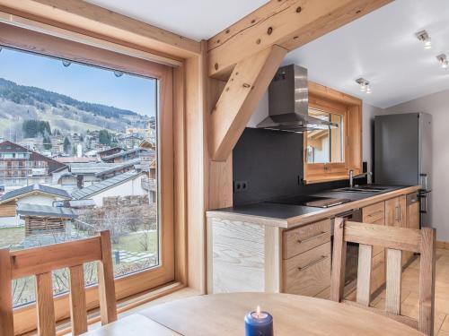 une cuisine avec une table et une grande fenêtre dans l'établissement Charmant T3 au centre de Megève, balcon, proche pistes, garage, 4 pers, classement 3 étoiles - FR-1-453-96, à Megève
