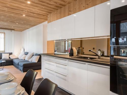 une cuisine avec des armoires blanches et un salon dans l'établissement Appartement rénové 4 chambres, centre de Megève, proche télécabine, 8 pers., parking inclus - FR-1-453-173, à Megève
