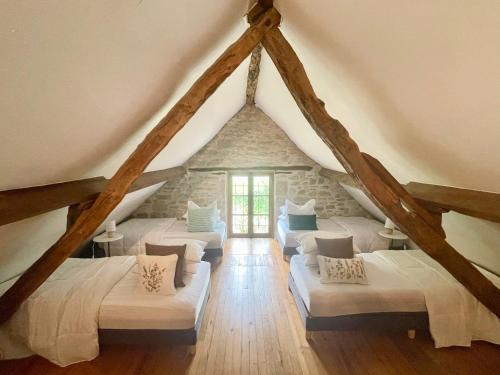 a room with a bunch of beds in a attic at Domaine du Bonheur en Pierre avec Piscine, Proche Sarlat in Carlux