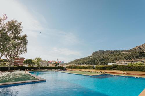 a large swimming pool with a mountain in the background at Camping La Sirena in L'Estartit