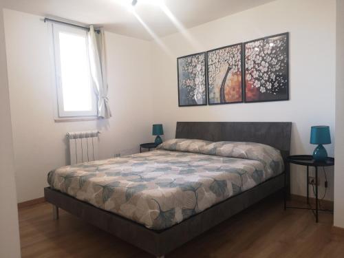 a bedroom with a bed and two lamps and a window at HomyHome in Civitavecchia
