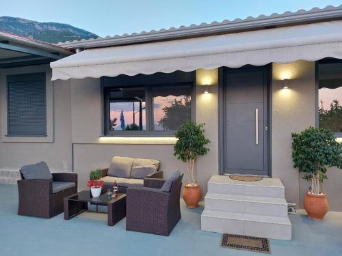 a patio with chairs and a couch and a table at Iliovasilema in Mírton
