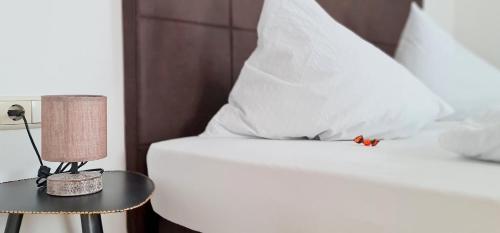 a bed with a white pillow and a table with a lamp at Apartment Traube - Stelvio in Stelvio