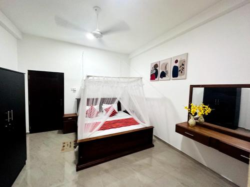 a bedroom with a bed with a net on it at DreamScape Holiday Apartment in Kalutara
