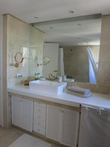 a bathroom with a sink and a large mirror at Sotogrande Duplex near Polo, 2 terraces, 2 pools, full south, 7' drive to beaches and Port, 4 people in Sotogrande