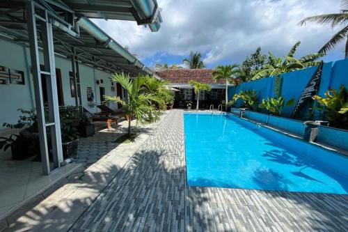 uma piscina no quintal de uma casa em Capital O 92615 Villa Utama D'alas Purwo em Ringinpintu