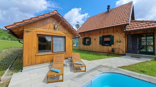 a house with a pool and two chairs next to it at Villa Pribila in Jasenak
