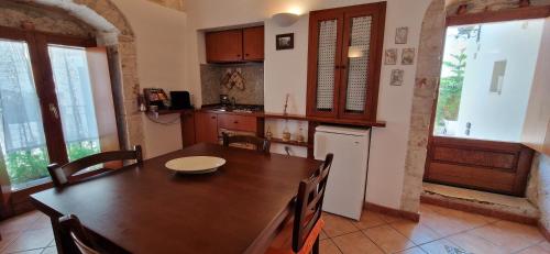 a kitchen with a wooden table and a refrigerator at Sotto l'arco in Sammichele di Bari