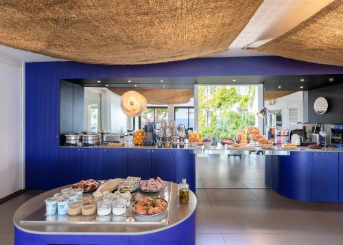 un buffet avec de la nourriture sur un mur bleu dans l'établissement Les Elmes - Hôtel, Spa & Plage Privée, à Banyuls-sur-Mer