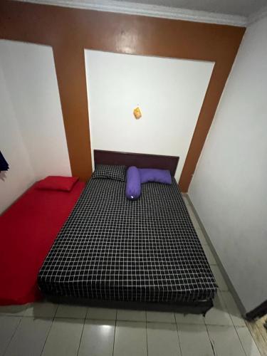 Cama en habitación con colchón morado en DAMPAR BEACH SELATAN 1 KM69, 