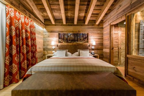 a bedroom with a large bed and wooden walls at Nendaz 4 Vallées & SPA 4* Superior in Nendaz
