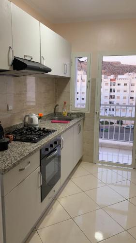 a kitchen with white cabinets and a stove top oven at TRIO in Agadir