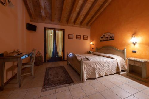 a bedroom with a bed and a desk and a window at Agriturismo Ca' Del Gal in Valeggio sul Mincio