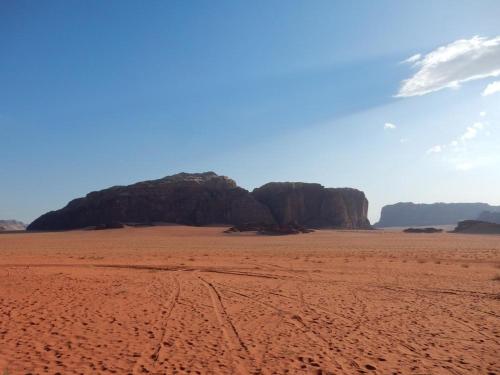a desert with some rocks in the background at Wadi Rum Nights in Wadi Rum