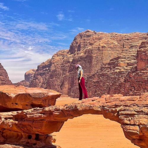 a person standing on a bridge in the desert at Wadi Rum Nights in Wadi Rum