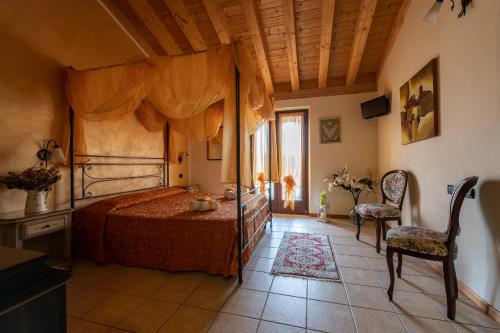 sypialnia z łóżkiem i dwoma krzesłami oraz oknem w obiekcie Agriturismo Ca' Del Gal w mieście Valeggio sul Mincio