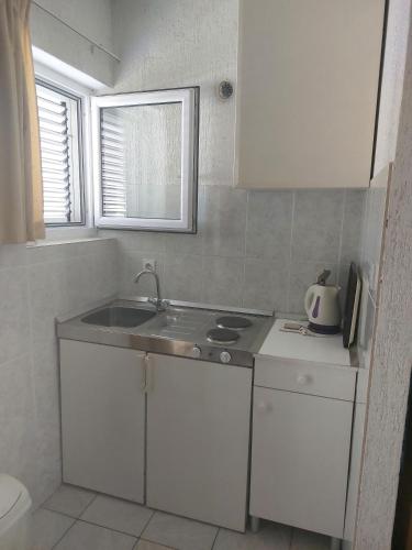 a kitchen with a sink and a counter top at Apartmani Džapo in Srima