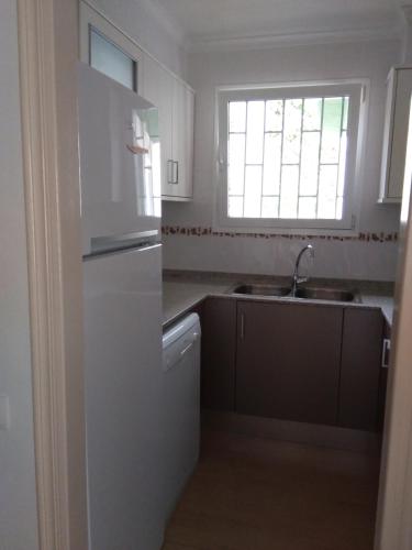 a kitchen with a white refrigerator and a sink at Apartamento Lepanto Playa in Les Cases d'Alcanar