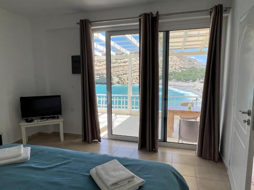 um quarto com uma cama e vista para o oceano em Bella Vista Luxury Apartment em Matala