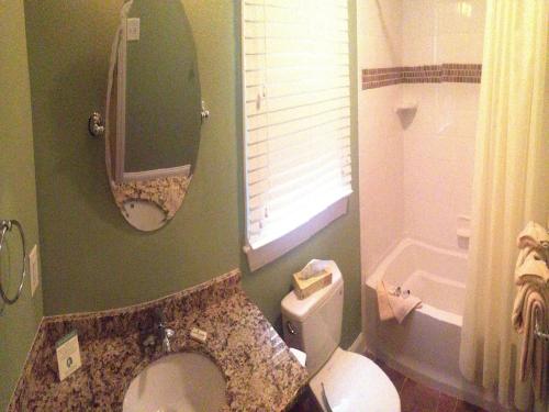 a bathroom with a toilet and a sink and a mirror at InnSeason Resorts HarborWalk in Falmouth