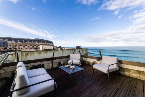 - un balcon avec des chaises et une table donnant sur l'océan dans l'établissement LIGHTHOUSE KEYWEEK Apartment Biarritz, à Biarritz