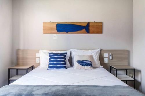1 dormitorio con 1 cama con almohadas azules y blancas en Casa com Piscina a 7 minutos da Praia em Canasvieiras QJ1126 en Florianópolis