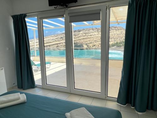 a bedroom with a window with a view of the beach at Bella Vista Luxury Apartment in Matala