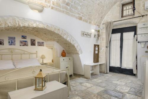 ein Schlafzimmer mit einem Bett und einer Steinmauer in der Unterkunft Ostuneon 900 by Wonderful Italy in Ostuni