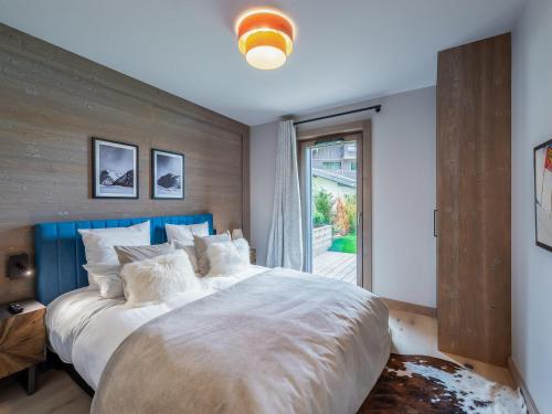 une chambre avec un grand lit et une fenêtre dans l'établissement Appartement à Megève avec espace bien-être, piscine, sauna et salle de sport - FR-1-569-35, à Megève