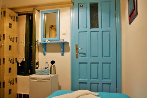 a blue door in a room with a sink and a mirror at Cemil İpekçi Pension in Bodrum City
