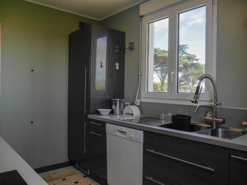 une cuisine avec un évier et une fenêtre dans l'établissement Maison de Famille sur la Côte Sauvage - FR-1-418-204, à Bangor