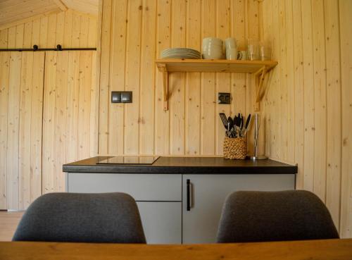 a kitchen with a counter with two chairs in it at Skårungen - Hotel, Cabins and Camping in Kabelvåg