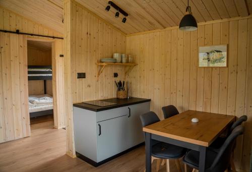 a kitchen and dining room with a table and a bed at Skårungen - Hotel, Cabins and Camping in Kabelvåg