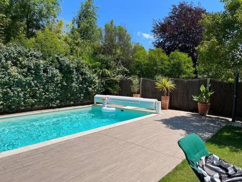 a swimming pool with a bench in a yard at Belle maison familiale Basque in Bayonne