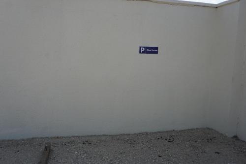 a white wall with a blue sign on it at Riva Home in Saint-Aignan