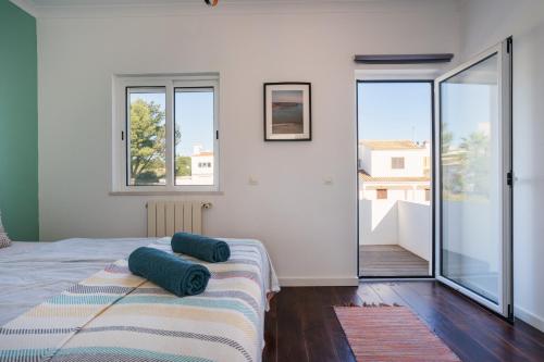 una camera da letto con un letto con cuscini blu di Beach House Clerigo - 2 Unique Apartments ad Aljezur