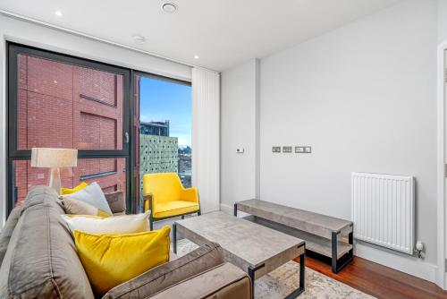a living room with a couch and a table at JOIVY Tasteful flat with balcony in London