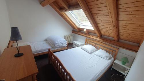 een slaapkamer met 2 bedden, een bureau en een raam bij Rochesson - Le Chalet in Rochesson