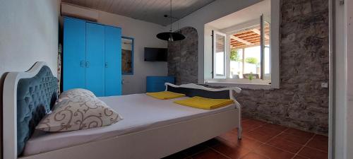 a bedroom with a bed with blue cabinets and a window at Beach House Buljarica in Petrovac na Moru