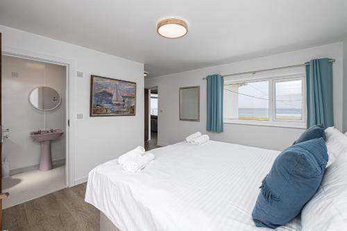 a bedroom with a large white bed and a window at Angorfa in Caernarfon