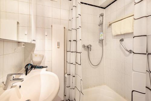 a white bathroom with a shower and a sink at Kloster Meister Haus Apartment 11 in St. Blasien