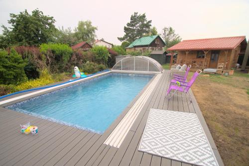 a swimming pool with a purple chair on a deck at Bouda Berounka 