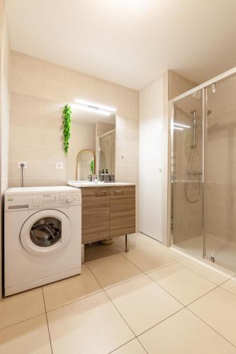 La salle de bains est pourvue d'un lave-linge et d'une douche. dans l'établissement Viviane - T3 reposant - Jardin - Garage - Wifi, à Vannes