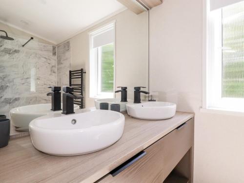 een badkamer met 2 wastafels en een grote spiegel bij 63 The Maples in St Austell