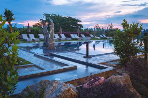 a pool with chairs and a fountain in a garden at Le Ali Del Frassino in Peschiera del Garda