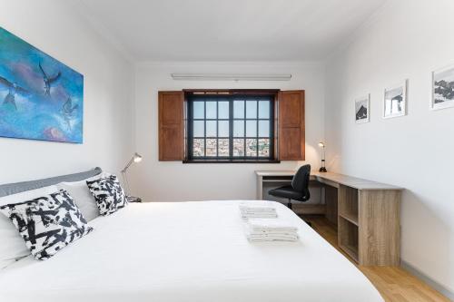 a bedroom with a bed and a desk and a window at Dream Views of Porto - Private Apt in Gaia by Lisbeyond in Vila Nova de Gaia
