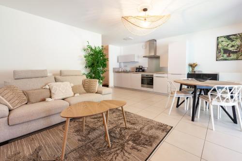 un salon avec un canapé et une table dans l'établissement Viviane - T3 reposant - Jardin - Garage - Wifi, à Vannes