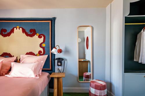 Schlafzimmer mit einem Bett und einem Spiegel in der Unterkunft Hôtel de La Boétie in Paris